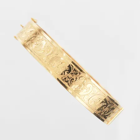 Armring med mönsterdekor, öppningsbar, innermått 63mm, bredd 12mm, gravyr, tillverkad av Ceson Göteborg 1977, 18K guld Vikt: 16,8 g