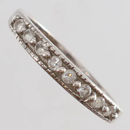 Ring med vita stenar stl:19¾ bredd 2-3,5mm skev Silver 925/1000. Vikt: 2,6 g
