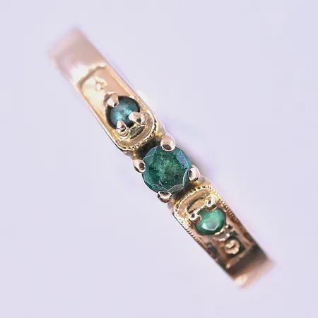 Ring med gröna stenar stl:18¼ bredd 3 mm 18K. Vikt: 2,2 g