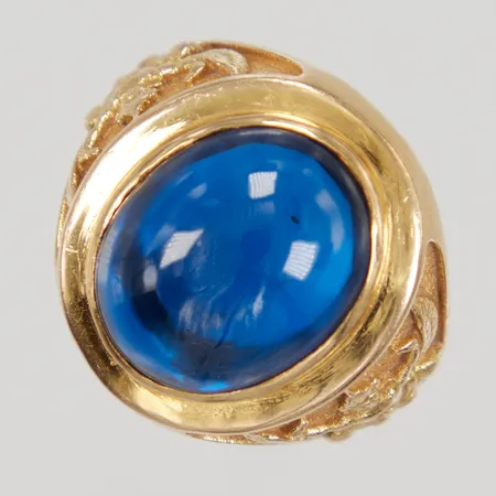 Ring med blå sten stl:19¾ bredd 4,3-22mm, motiv av Garuda, ostämplad 18K, Bruttovikt: 18,6g.