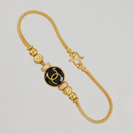 Armband 17cm, svart emaljkula och vita stenar, bredd 2,6-12mm, 23K. Bruttovikt: 7,6g.