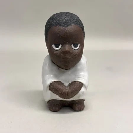 Figurin Syd Lisa Larson Rörstrand, ur serien All Världens Barn, höjd 11cm, stämplad i gods, delvis glaserat stengods, ojämnheter i glasyren, visst ytslitage, otydlig stämpel