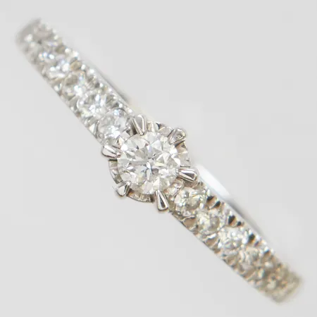 Ring med diamanter 1 x ca.0,12ct samt 14 x ca.0,01-0,015ct, stl:17½, bredd: 1,5-5mm, GHA, vitguld, 18K Vikt: 2,7 g