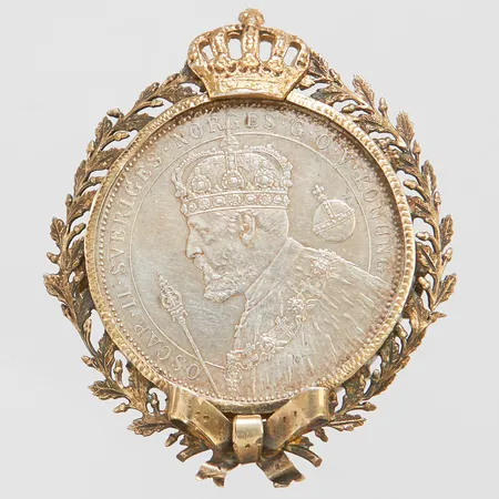 Brosch/Mynt med ram i metall Oscar ll Sveriges och Norges G.O.V. Konung, två kr, 1872-1897, Ø40mm, silver 830/1000, bruttovikt 20,7g, beräknad silvervikt 15,0g