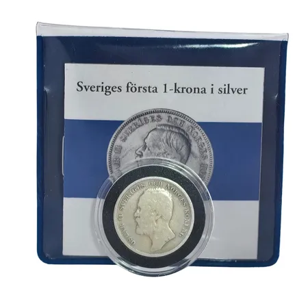 Silvermynt Oscar II 1 krona "Sveriges första 1-krona i silver" 1903 (utgivningsår 1876-1907), Ø25 mm, 80%, förvaras i myntkapsel liksom plastkonvolut från Mynthuset Sverige, informationsfolder Vikt: 7,5 g