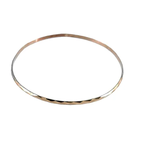 Armring i 14K guld, fasetterad modell, rund form, ej öppningsbar, inre omkrets 22,2 cm, bredd 2,5 mm, en lagning på skenan Vikt: 4,6 g