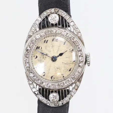 Damur i platina Ø21mm, med diamanter 67xca0,01-0,02ct samt 2xca0,10ct, guillocherad urtavla, blånerade visare, omkring 1910-tal, millegriffdekor med visst slitage, läderband med slitage, saknar stenar, går ej (servicebehov) bruttovikt 15,8g