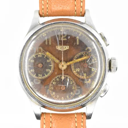 Herrur Heuer stål, manuell, Ø36mm, kronograf, serienr 50000, verknr 750268, troligen valjoux 71, ca 1940-tal, patinerad bruntonad urtavla, slitna visare, åldersrelaterat bruksslitage, läderband ej original, fungerade vid testtillfället, inga tillbehör. Vikt: 0 g