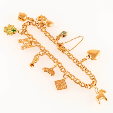 Armband Bismarck med 10 berlocker: dalahäst, trumpet, kikare mm, längd 20cm bredd 5mm, säkerhetskedja, skadad emalj fyrklöver, 18K 15,6g. 