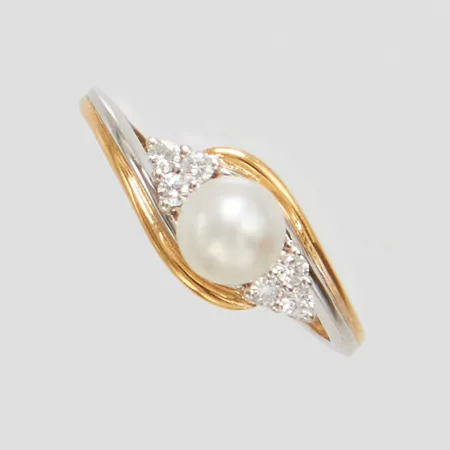 Ring med en odlad pärla Ø5,5mm samt 6 diamanter 0,10ctv enligt gravyr, stl:17, bredd: 1,5-7,2mm, tvåfärgad, visst slitage på pärlan, 18K Vikt: 2,4 g