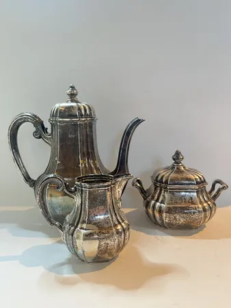Ett set kaffekanna höjd 25cm Ø11cm, gräddsnipa höjd 8cm Ø9cm, sockerskål höjd 7cm Ø11cm, gravyr, silver 830/1000 Vikt: 893,2 g