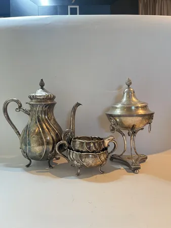 Ett set kaffekanna höjd 22cm Ø12cm, gräddsnipa höjd 10cm Ø8cm, sockerskål med lock höjd 12cm bredd 11cm, gravyr, silver 830/1000 Vikt: 1059 g