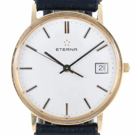 Herrur Eterna i 18K guld med svart (defekt) läderband. Boett Ø 33,5 mm, datumvisare, quartz, repigt plexiglas, gravyr. Går ej - Batteribyte krävs? Bruttovikt: 27,2g. 