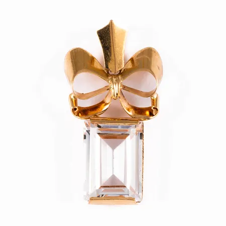 Hänge i 18K guld: Rosett och ofärgad (syntetisk) sten. Det är 10,5 - 17 mm brett, 31,5 mm långt inkl. ögla och väger 4,2g. Fåtal nagg på fasetten.