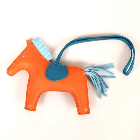 Bag Charm Hermès, Accessoire de sac "Rodeo", i orange och blått kalvläder, med kvitto från NK Stockholm 2018, i originalask. 