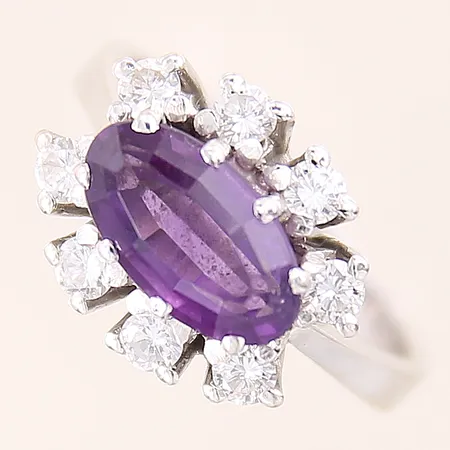 Ring med lila sten samt diamanter 8 x ca 0,05-0,07ct, flertalet indikerar på att vara syntetiska, stl 16¾, bredd 3,3-12mm, smärre nagg på sten, vitguld, 18K Vikt: 6,2 g