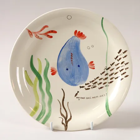 Tallrik, Löja", Stig Lindberg för, Gustavsberg, tillverkad under 1948-1961, flintgods med handmålad dekor av fiskar och sjöväxter, Ø24,5cm, slitage, krackelyr, två större glasyrskrickor undertill (ej genomgående). Skickas med paket.