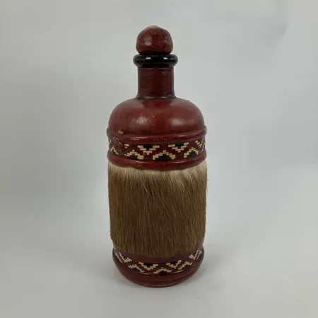 Glasflaska med läderarbete, höjd ca 21cm, rem till kork saknas, troligen Västafrika, limrester, åldersbetingat skick.