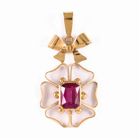 Hänge i 18K guld: Rosett och blomma med ceriserosa sten. Det är 15 - 19,5 mm brett, 38 mm långt inkl. ögla och väger 3,4g. Stämplad X8 (1948), GVH (Guldvaruhuset AB, Stockholm), 18K och kattfot. 