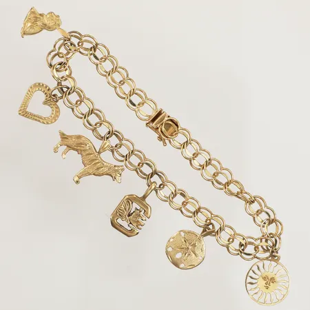 Armband med sex berlocker, längd 19,5cm, bredd 6mm, skev, skadad i länken, 14K  Vikt: 12,1 g