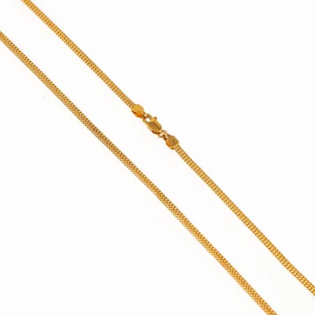 Kedja i 21K guld. Den är 40,5 cm lång, 2 mm bred, 0,7 mm hög och väger 4,1g. Karbinhake. Ojämnheter.