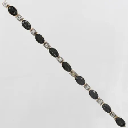 Armband med rosenslipade onyxer samt antikslipade färglösa topaser, en vit sten i glas, defekt/av/stift saknas, längd 16,5cm, bredd 7mm, onyxer fattade i 14K guld, topaser fattade i silver  Vikt: 10,2 g