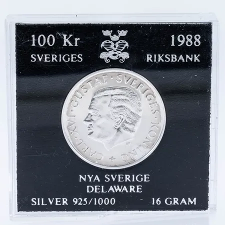 Mynt i silver (925/1000) Ø 32mm, Nya Sverige Delaware, Carl XVI Gustaf Sveriges Konung, år 1988, nominellt värde 100kr, Sveriges Riksbank, etui, Vikt: 16,0g. 