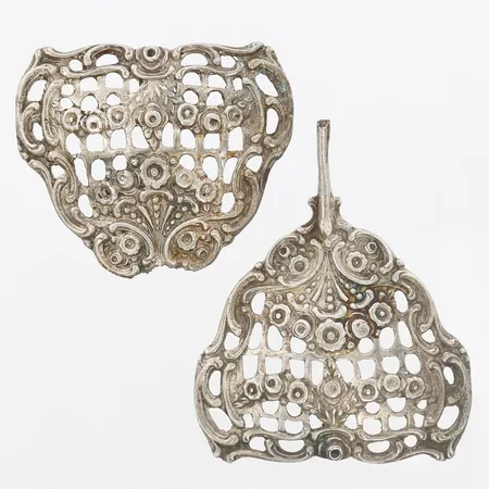 Två delar silver, troligtvis från köksredskap, längd: 57mm, bredd: 46, svensk importstämpel, 830/1000 silver  Vikt: 18,9 g