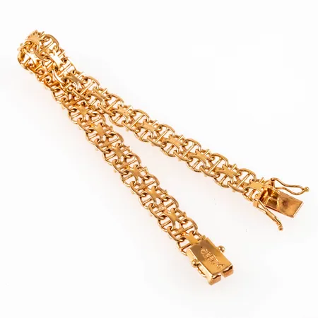 Armband X-länk med stav i 18K guld. Det är 19,5 cm långt, 8,5 mm brett och väger 18,7g. Kistlås. Stämplad Q9 (1966), GK (Ge Kå Smycken, G Kaplan, Stockholm), 18K och kattfot. 