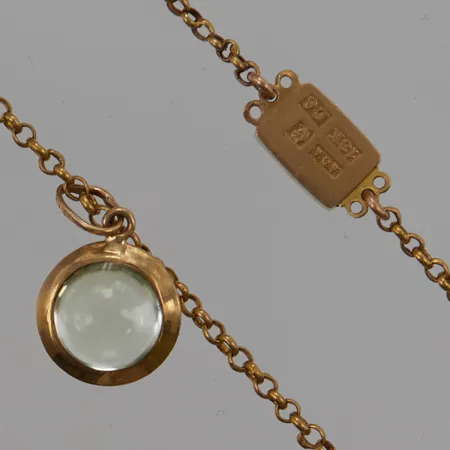 Kedja 40cm, bredd:1,6mm, hänge med grön sten, mästarstämpel "AGA", E6=1859, 18K 5,6g.