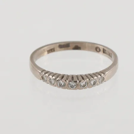 Ring med 7 diamanter 0,12ctv enligt gravyr, Ø17¼, bredd: 2,1mm, vitguld, 18K, 2,5g.