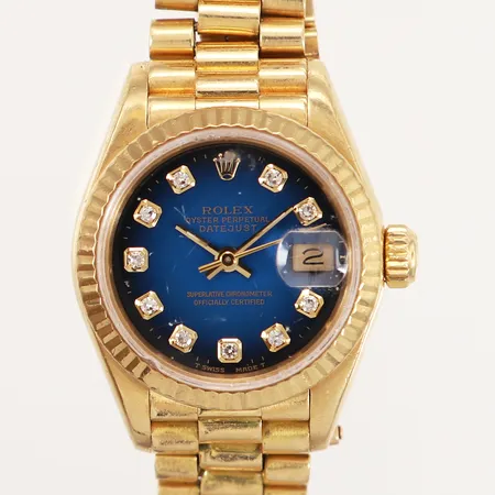 Damur Rolex Oyster Perpetual Date Just, 18K, blå urtavla, diamantindex, automatisk, ref-nr: 69178 serie-nr: N170582, årtal ca 1991, cal: 2135, verk-nr: 1926616, boett-nr: 690001A, Ø26mm, länk ca16cm, länkens nr: 8570F, repigt glas med nagg, inga tillbehör Vikt: 74,1 gram