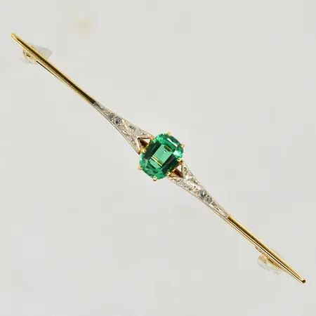 Brosch med rosenstenar och grön sten, längd 68 mm, bredd 8 mm, nagg på mittsten, 18K. Vikt: 4,7 g