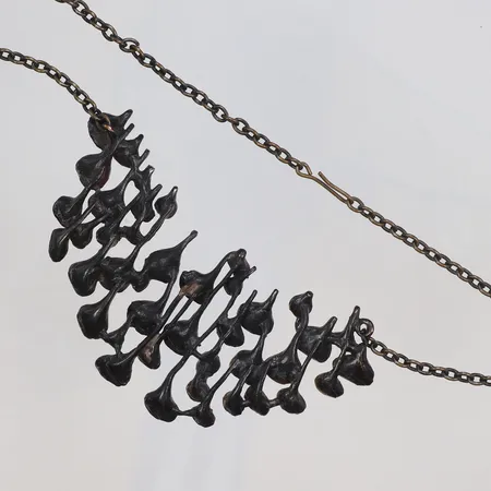 Collier i brons längd 60cm bredd 3-65mm, troligen Hannu Ikonen modell "Lava", ca 1960/70-tal, Finland