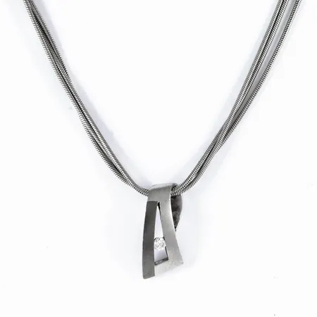 Collier (3-radig ormlänk) i silver (925/1000): Hänge med vit sten (cz). Det är 42 cm långt, 3 mm brett. Hänget mått 9 x 18 mm. Total vikt: 14,0g. Karbinhake. Stämplad JAG (Jens J. Aagaard, Danmark), 925.