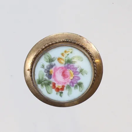 Brosch med plakett i porslin Ø38mm, baksida med små skador spår av förgyllning, något skev nål, Helsingfors Finland 1947 silver 813/1000 Vikt: 7,3 g