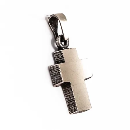 Hänge Kors i lätt oxiderat silver(925/1000). Det är 9 mm brett, 19,5 mm långt inkl. ögla och väger 0,8g. Karl Laine för Finnfeelins, Finland.