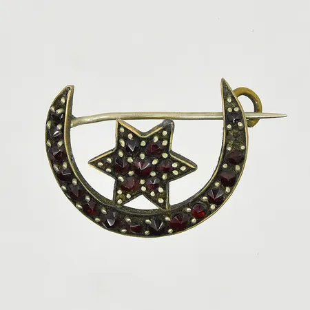 Brosch med granater, längd 26 mm, bredd 20 mm, en sten saknas, metall.