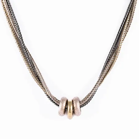 Collier (3-radig spiga) i silver (925/1000): Delvis förgylld och oxiderad. Dekor/hänge bestående av 3 ringar. Det är 42 cm långt, 5 mm brett och väger 23,9g. Karbinhake. Svag förgyllning och oxid.