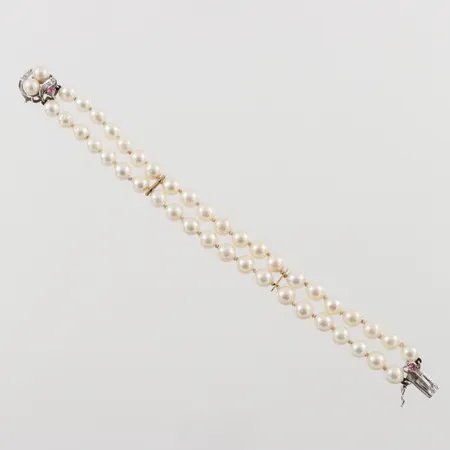 Tvåradigt pärlarmband, längd: 18cm, bredd: 13,5mm, pärlornas omkrets Ø6,7mm, vitguldslås med pärlor i 18K. Vikt: 0 g