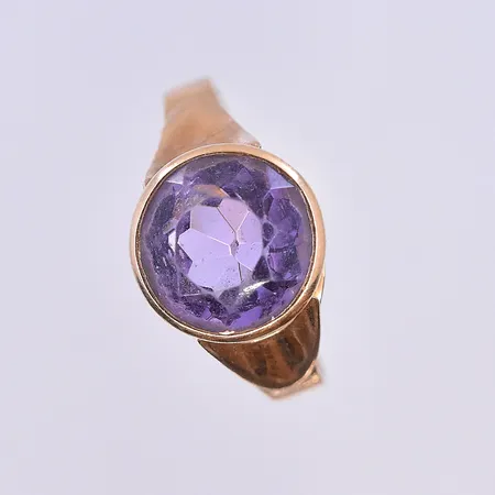 Ring med lila sten, stl 17½, bredd 2-10 mm, 18K. Vikt: 2,5 g