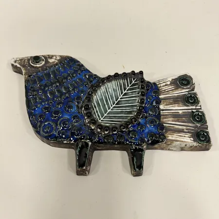 Väggplakett påfågel, Lisa Larsson, keramik, ca 20x28cm, spricka upptill i kanten, upphängningsanordning   Vikt: 0 g Skickas med postpaket.