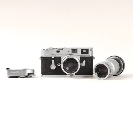 Kamera Leica M2, serienummer 1112535, 1965, servicesigill E, objektiv Summaron 1:2.8/35, serienummer 1947665, 1962, samt objektiv Elmar 9cm 1:4, serienummer 1213424, 1954, med Leica-Meter MR, servicebehov, slitage, bucklor, märken, långa tider något sega, optik samt sökare med mindre damm, mindre vulkanitbortfall, Summaron med tröga reglage. - FINNS FÖR VISNING PÅ PANTBANKEN ÖSTERMALM. Vikt: 0 g