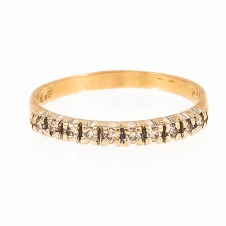 Ring i 18K guld med 10 x c:a 0,025ct (c:a Crystal(J)/si) briljantslipade diamanter i klofattning. Den är i storlek 18, är 2 - 2,5 mm bred och väger 2,2g. Stenstorlek 0,24ct ingraverat. Tidigare rodiumplätering på fattning delvis bortnött. Vassa klor. 