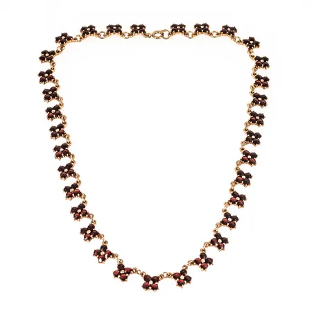 Colliér i förgyllt silver (830/1000) med granater. Det är 39,5 cm långt, 9 mm brett och väger 21,3g. Stämplad HE (Heribert Engelbert AB, Stockholm), 830S, S och kattfot. 