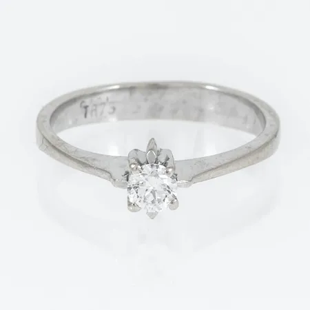 Ring i 18K vitguld med 1 x c:a 0,20ct briljantslipad diamant. Den är i storlek 16, är 3 - 5,5 mm bred och väger 2,8g. 