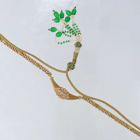 Collier med vita stenar, tygband med pärlor och plaststenar, ca 96cm, hänget ca 40x12mm, 18K bruttovikt 21,3g Vikt: 21,3 g