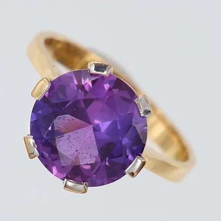 Ring med lila sten, stl: 16½, bredd 2,8-13mm, 18K. Vikt: 4,1 g