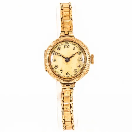 Damur i 14K guld med 18K band. Boett Ø 21,5 mm med gravyr. Fuktskadad urtavla. Repigt plastglas. Manuellt urverk. Ojämnt band. Kistlås. Totallängd 15,5 cm. Bruttovikt 14,8g. 