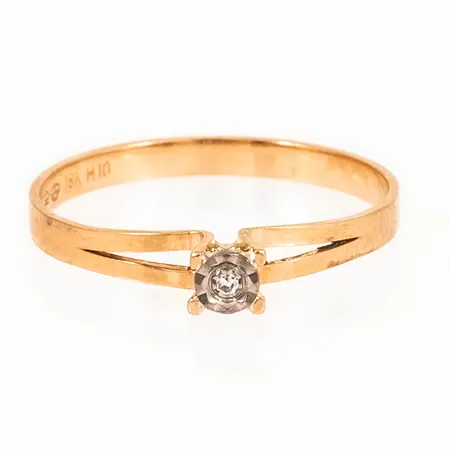 Ring i 18K guld med en diamant ca 0,01ct; fattad i vitt guld. Den är 2 - 3,4 mm bred, är i storlek 17¼ och väger 1,4g.